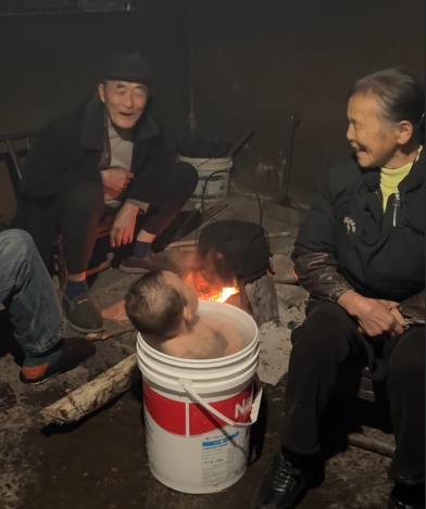 太爺爺一句想你了，一歲半萌娃隨父母跨越三百公里回村，網友：烤火洗澡就像自己小時候