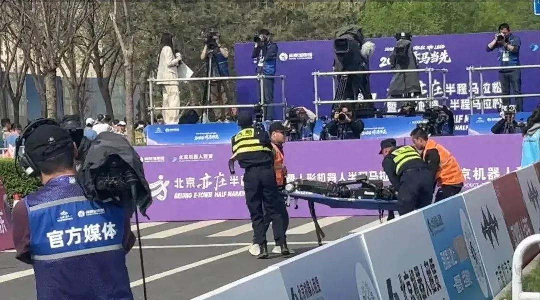 宇樹H1機器人半馬賽場終點“累倒”，現場工作人員緊急用擔架將其抬離賽道；這臺H1此前排位賽中曾跑出亮眼成績，被視作熱門選手